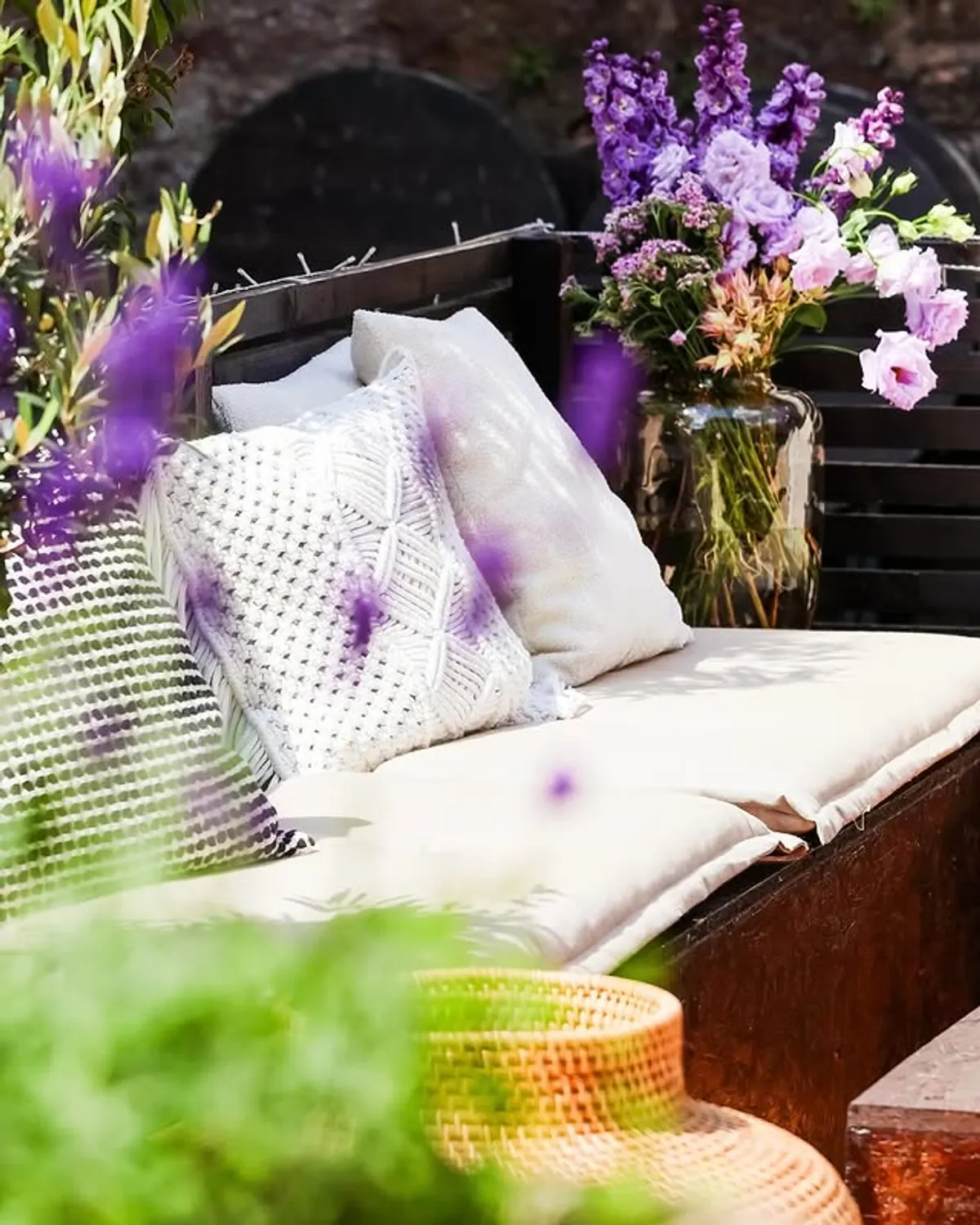 Sitzbank mit Kissen und Blumen im Innenhof