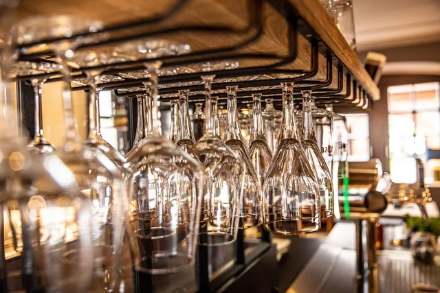 Gläser über der Bar im Abendlicht